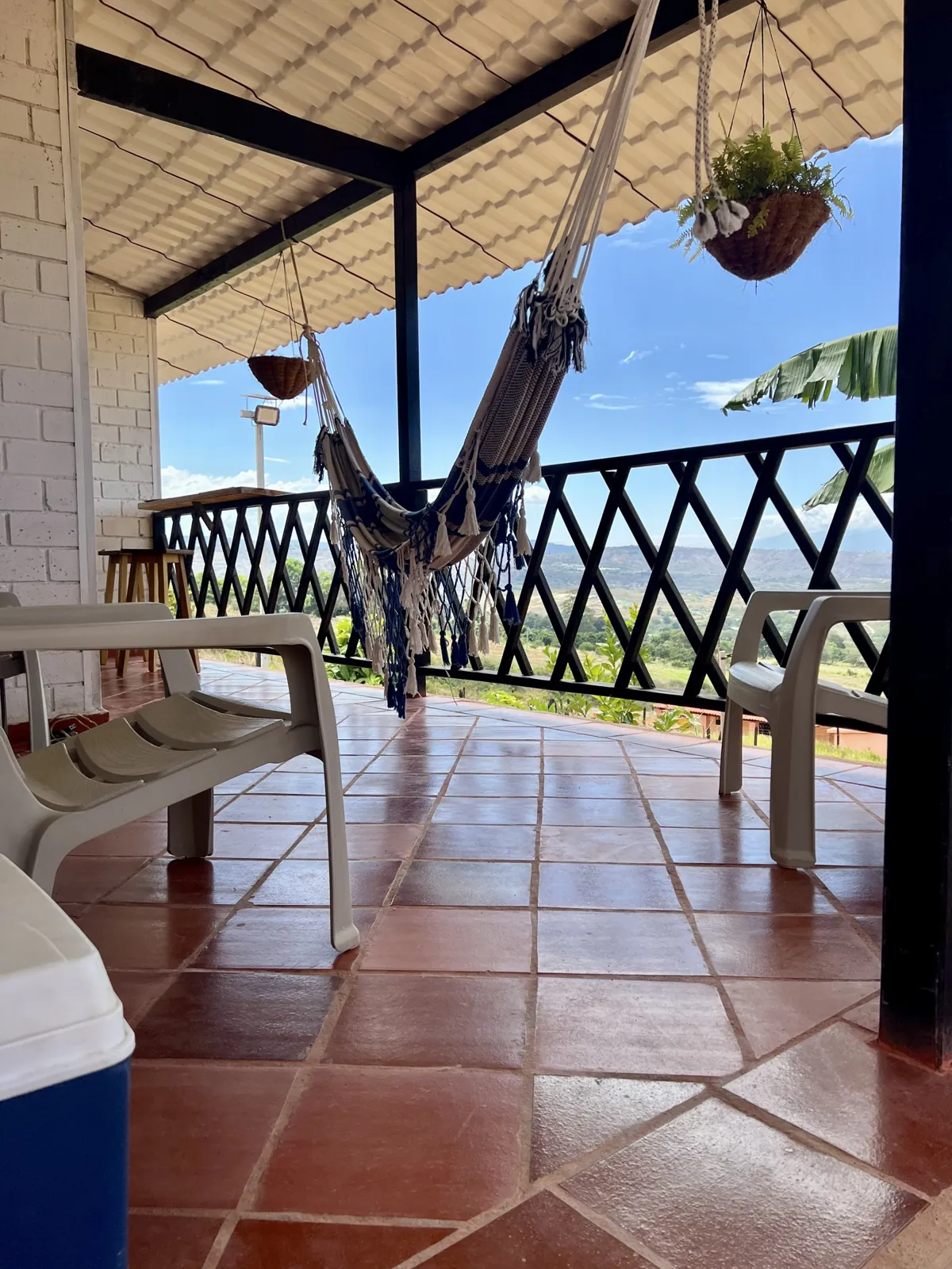 Corredor de la casa Diamante con piso en terracota, hamaca y vista