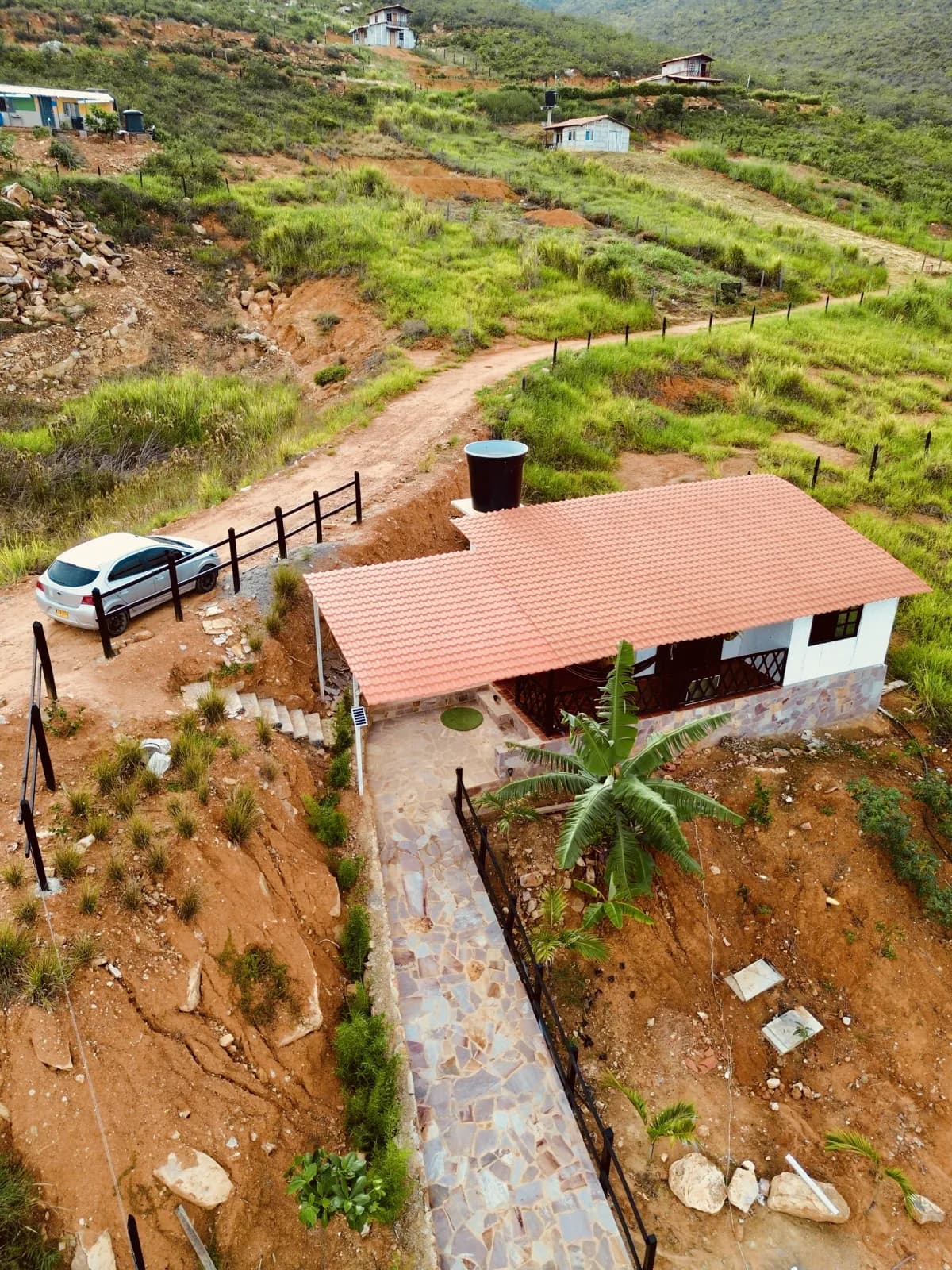 Vista aérea de casa prefabricada terminada con acceso en piedra